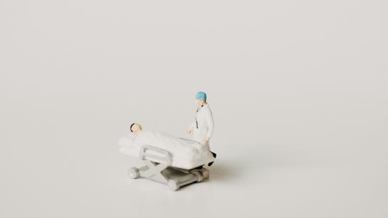 small figures, doctor with a patient on the hospital bed