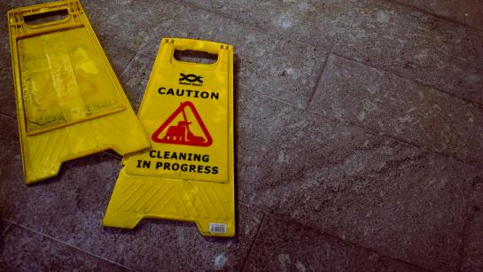 yellow sign on the floor - caution, cleaning in progress