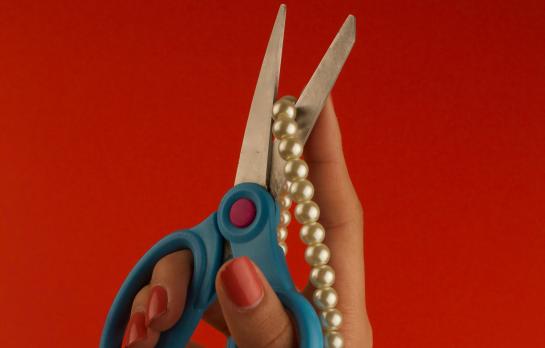 scissors cutting a pearl necklace
