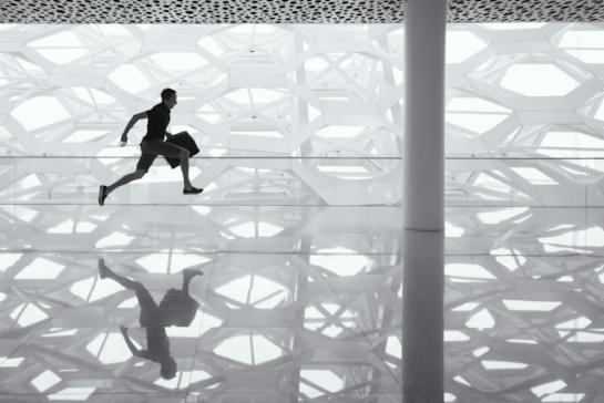 a man with a suitcase running in the modern building