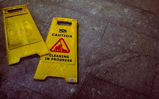 yellow sign on the floor - caution, cleaning in progress