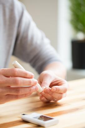 A person measuring sugar level in blood