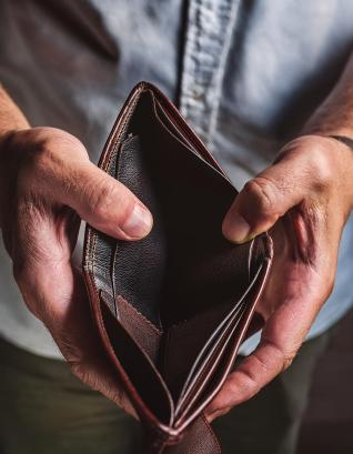 A man holding an empty brown wallet with both hands. 