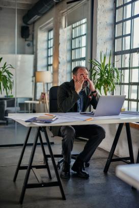 Businessman looking very anxious in his office at work 